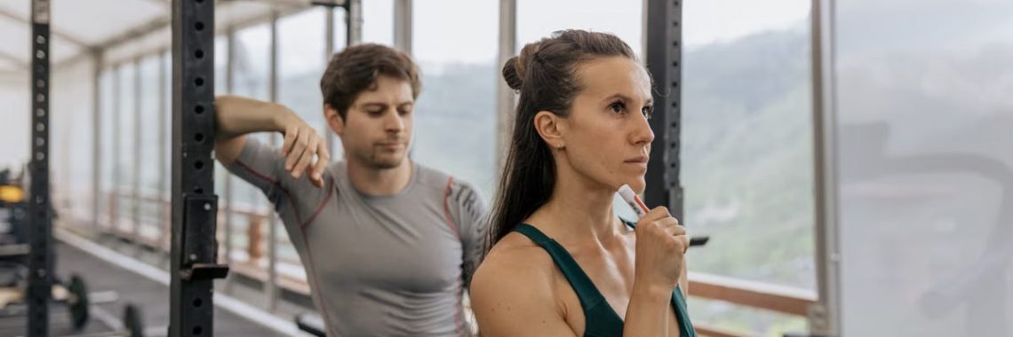 A fit couple engaged in gym exercises. Indoor workout with focus on fitness goals.